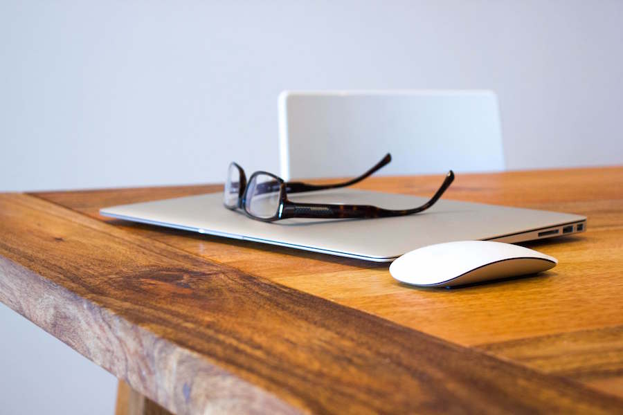 glasses resting on laptop on a table