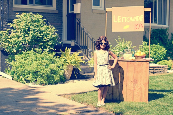Young girl selling lemonade at stand